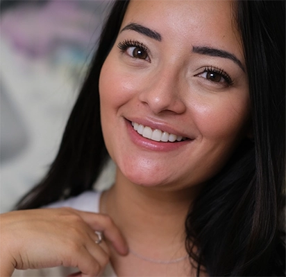 Mujer sonriente tras haber recibido un tratamiento de carillas dentales de Smysecret.